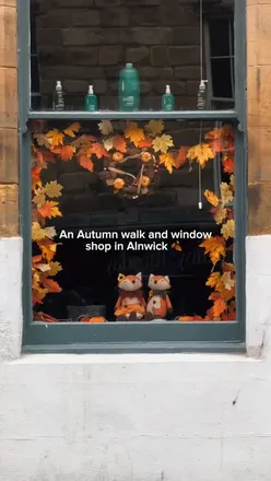 Evening stroll in Alnwick, showcasing cozy autumn vibes around charming shops and fallen leaves.