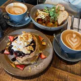 Breakfast and coffee at Residence Leeds, showcasing delicious pancakes and vibrant café atmosphere.