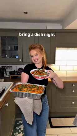 Vegans enjoying a bring-a-dish night with plant-based food, drinks, and laughter in a festive setting.