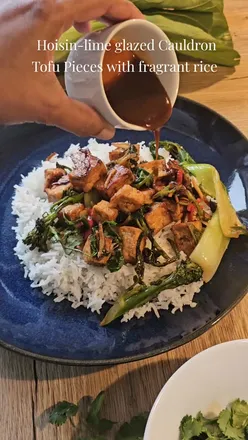 Hoisin-lime glazed tofu pieces on fragrant basmati rice, served with vibrant veggies for a plant-based delight. 🌱🍚