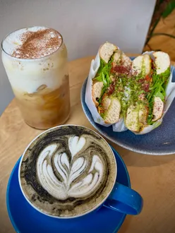 Seasonal drinks at Hey Brew in Selly Oak: iced pumpkin spice latte and hot vanilla charcoal latte enjoyed in cozy cafe setting.