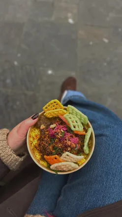 Enjoying authentic Indonesian food at Waroeng Nona's food truck in Cardiff city centre, offering a taste of Indonesia.