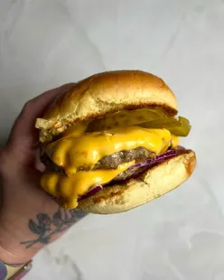 Delicious smash burger topped with pickles, onions, ketchup, and mustard, served with a side of fries.