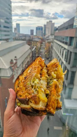 Loaded skins grilled cheese sandwich with crispy potatoes, jalapeños, and sourdough at Arndale food market, Manchester.