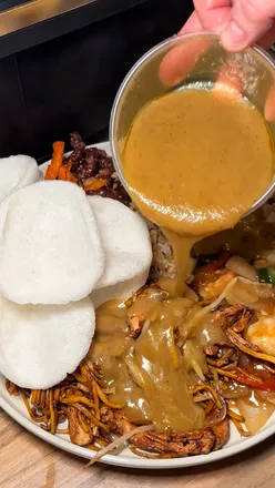 Delicious Chinese takeaway spread featuring crispy chilli beef, chicken chow mein, and prawn crackers from Hing Thai.