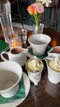 Enjoying a rich, thick hot chocolate with whipped cream at Petit Cafe Lark Lane, Liverpool, perfect for autumn indulgence.