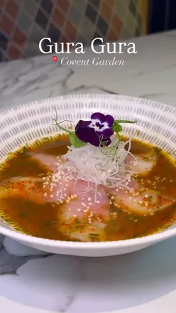 Diners enjoying a vibrant Pan-Asian meal at Gura Gura in Covent Garden, featuring sushi, curry, and cocktails.