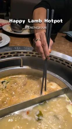 Family enjoying interactive hotpot dining at Happy Lamb in Chinatown, Birmingham, featuring flavorful broth and all-you-can-eat menu.