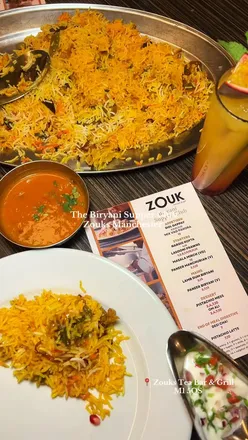 Guests enjoying a cozy evening at Zouktea Bar's Biryani Supper Club in Manchester, savoring delicious biryani and pakoras.