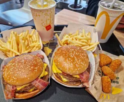 Enjoying a Maple BBQ & Bacon Double Quarter Pounder and lukewarm Mac and Cheese Triangles at McDonald's UK.