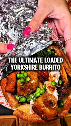 Fully loaded Yorkshire pudding wrap with roast chicken, veggies, and gravy for a cozy Sunday dinner.