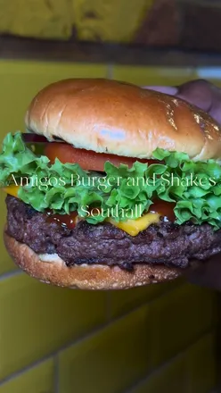 Friends enjoying a feast at Amigos Burgers, featuring burgers, fries, milkshakes, and loaded churros. #FoodReview #LondonEats