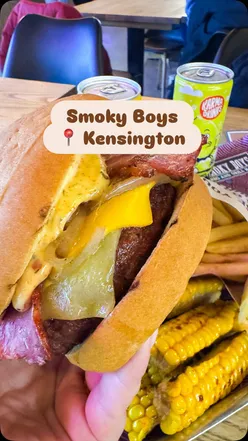 Parent and child enjoying a gluten-free burger from Smoky Boys after visiting the Natural History Museum in London.