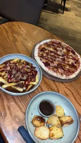 Festive pizza and loaded fries at YOLO Townhouse in Newcastle, celebrating holiday flavors with festive dishes.