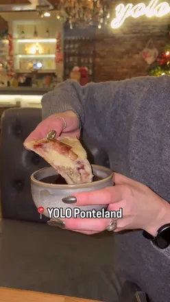 Festive pizza with cranberry sauce and toppings at YOLO Ponteland, showcasing holiday flavors in a cozy venue.