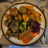 Vegan Christmas dinner featuring a seitan roast, pigs in blankets, roast potatoes, and mushroom gravy.