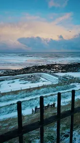 A montage video capturing a snowy Saturday in a northern UK town, featuring scenes of the local area, a beach, and visits to a coffee van and a bakery stall. The video focuses on the atmosphere of the day rather than a detailed showcase of the venues.