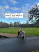 A lifestyle shot featuring a parent with a pram on the grounds of Kesgrave Hall, intended to convey a relaxing, family-friendly getaway.