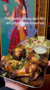 A short, rhythmic montage showcasing various Indian street food dishes at Mr Chaat in Manchester. The video features close-up shots of food being prepared and eaten, including noodles, chicken, chaat, curry, naan, mango lassi, and chai, set against the backdrop of the restaurant's interior.