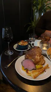 A short, aesthetic montage showcasing a Sunday roast dinner at a venue in Hertfordshire. The video features close-up shots of roast beef, crispy potatoes, Yorkshire pudding, cauliflower cheese, and various drinks, set to music with simple text overlays.
