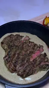 A montage of various dishes and drinks at Mynk Steakhouse, featuring close-up shots of lamb chops, prawns, steak, pasta, and dessert. The video focuses on the presentation and texture of the food, using smooth, controlled camera movements.