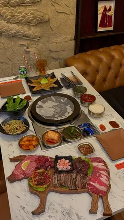 Group enjoying Korean BBQ at An-Nyeong in Manchester, featuring halal beef, chicken, and a vibrant tasting platter.