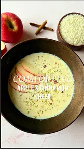 A recipe tutorial video featuring a creator demonstrating how to make a comforting Apple and Cinnamon Kheer (Indian rice pudding). The video combines talking-head segments with close-up shots of the ingredients and the cooking process, ending with a final taste test.