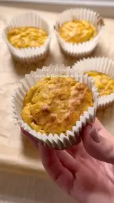 A concise, step-by-step recipe video demonstrating the preparation of baby-friendly carrot and banana muffins. The video uses text overlays to guide the viewer through the mixing and baking process.