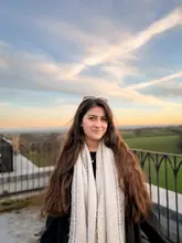 A high-quality portrait of a woman posing outdoors during the golden hour, suggesting a weekend getaway or travel experience. The image is well-composed with a scenic background, effectively conveying a relaxed and pleasant atmosphere suitable for promoting a hospitality venue like a hotel or retreat.