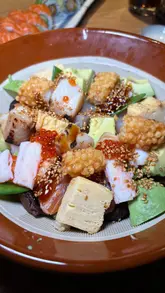 A food review video showcasing a visit to Sticks 'n' Sushi in Glasgow. The video features close-up shots of various sushi rolls, skewers, and a chirashi bowl, along with brief clips of the restaurant's interior. A voiceover provides commentary on the food and the dining experience.
