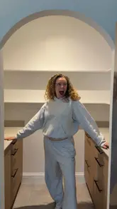 Excited influencer showcasing a newly organized pantry filled with essentials from Amazon Fresh's byAmazon range.