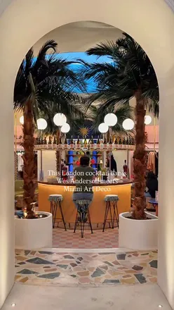 Whimsical pastel cocktail oasis at Black Lines bar, Chelsea, blending tropical kitsch with Art Deco elegance.