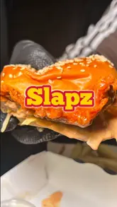A creator reviews a meal from a dark kitchen called Slapz, consisting of a flaming buttermilk chicken burger, chips, and a Maltesers milkshake. The video features the creator eating in their car, providing commentary on the taste and texture of the food.