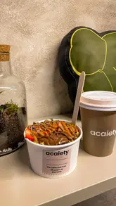 This video promotes a venue in Jesmond that combines a vintage clothing store with an açai and coffee bar. It features quick cuts of the shop's interior, the clothing racks, the menu, the coffee machine, and the preparation of an açai bowl, ending with a shot of the final product.