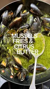 A fast-paced home cooking tutorial demonstrating how to clean and cook mussels with a parsley and citrus butter sauce, served with oven chips.