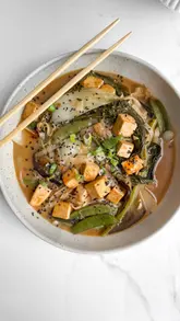A well-edited home cooking video showcasing three different winter soup recipes. The creator demonstrates the preparation process for roasted carrot, miso noodle, and lasagna soups, using text overlays to guide the viewer.