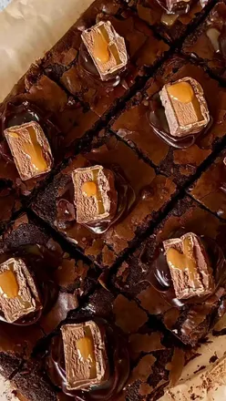 Mars Brownies🍫

January is far too long, cold and gloomy to eat healthy the whole time! Treat yourself to an indulgent, gooey, caramel brownie to brighten up your week!

Recipe:
225g unsalted butter 
60g cocoa powder
200g dark chocolate
1tsp vanilla extract
120g light brown sugar
210g icing sugar
3 large eggs
60g plain flour
50ml olive oil 
Pinch of salt
270g mars bars
100g milk chocolate chips (optional)
Chocolate ganache (optional)
Caramel sauce (optional)

1. Preheat the oven to 180c fan and line your baking tin with baking paper.
2. Cut your Mars bars into chunky 1 inch pieces and place in the freezer for 30 minutes whilst you make your brownie batter.
3. Chop your butter into cubes and melt in a saucepan over a low heat until golden and frothy (about 5 minutes). Then break the dark chocolate into the pan. Cook again for another 1 minute. Remove from the heat (it will carry on melting when off the heat). 
4. Add the cocoa powder, vanilla extract and olive oil to the chocolate mixture and mix well until combined.
5. In a stand mixer, whisk the eggs and light brown sugar for about 5 minutes until doubled in size and the colour becomes much lighter.
6. Add the icing sugar and whisk again until well combined.
7. Add the cooled chocolate mixture to the egg mixture and fold it together gently with a spatula.
8. Add the plain flour and pinch of salt and fold it together gently with the spatula. If using chocolate chips, add these in at this stage too.
9. Spread half of the brownie mix into your tin.
10. Add rows of the chopped up mars bars (saving 12 pieces for decoration) and then cover with the remaining brownie mix.
11. Bake in the centre of the oven for 30-35 minutes.
12. Leave to cool at room temperature for 1 hour in the tin.
13. Place the brownies into the fridge for 2 hours (this helps them become fudgy).
14. After this, cut the brownies into 12 pieces, pipe on the ganache, squeeze a tiny bit of caramel sauce on top and decorate with your remaining Mars bar pieces. Enjoy! 

#MarsBarBrownies #FudgyBrownies #brownierecipe #caramelbrownies #bristolcontentcreator