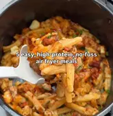 A close-up shot of a pasta dish being lifted from an air fryer basket with a white spoon, featuring text overlay about high-protein air fryer meals.