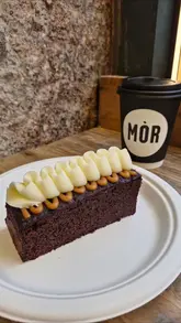 A short promotional video for Mòr Bakehouse in Glasgow, featuring shots of the exterior, the display counter, and various food items including pastries, sandwiches, and cakes.