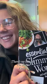 Excitedly holding a Slimming World pack with my face on the cover, celebrating my weight loss journey and achievements.