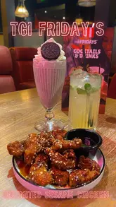 A short promotional video showcasing the 'Unlimited Sesame Chicken' offer at TGI Fridays, featuring close-up shots of the chicken, a milkshake, and a cocktail.