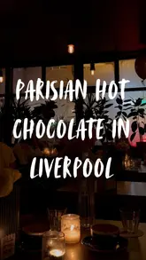 A short, atmospheric video showcasing a rich hot chocolate served with cream at Petit Cafe du Coin. The lighting is very dim, creating a cozy, intimate vibe, though the video is static and lacks a clear narrative or tour of the venue.