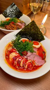A creator visits Robin's Ramen, located within the Supermarket of Dreams in London. The video features a variety of dishes including duck gyoza, prawn bao, bream, lobster ramen, and tonka ice cream, highlighting the quality and value of the menu.