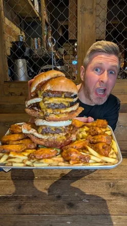 Competitor tackling the Gutbuster 2.0 Challenge at Craft Burger, racing against Joel Hansen's record time.