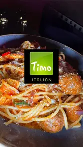 Couple enjoying Italian cuisine at Timo Restaurant in Leicester, featuring starters and desserts in a cozy setting.