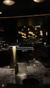 A short, cinematic montage showcasing the interior and food offerings of Lucky Cat by Gordon Ramsay in Mayfair. The video features slow-motion shots of cocktails, sushi, robata-grilled dishes, and dessert, set to music with text overlays highlighting the restaurant's suitability for date nights.