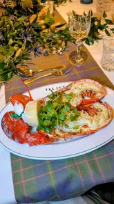 A montage video showcasing a Burns Night event at The Ivy, Glasgow. The video features high-quality shots of the table setting, various courses including haggis, lobster, and steak, as well as live harp music and the event atmosphere.