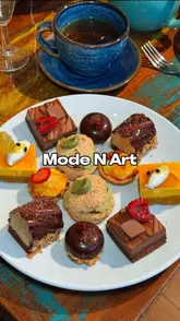 A review of an artisan bakery and cafe in Sale, focusing on their afternoon tea service. The video features the creator introducing the venue, highlighting the award-winning baker, and showcasing the various sweet and savoury items included in the afternoon tea, such as scones, smoked salmon profiteroles, and chocolate mousse domes.