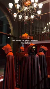 A promotional video showcasing The Traitors Live Experience in Covent Garden, highlighting the immersive set design, game elements, and the associated bar area.