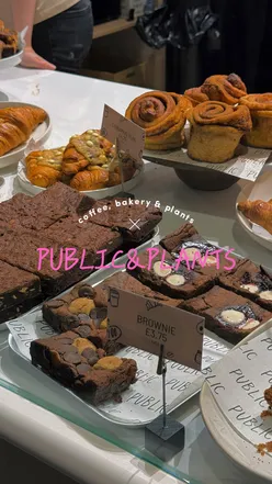 Visitors enjoying croissants and drinks at Public & Plants cafe in Leicester, featuring a bright, airy layout.